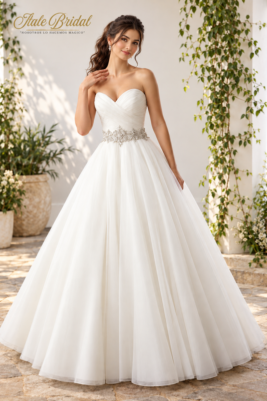 Vestido de novia corte princesa con corsé drapeado, escote corazón, cinturón joya y falda vaporosa.