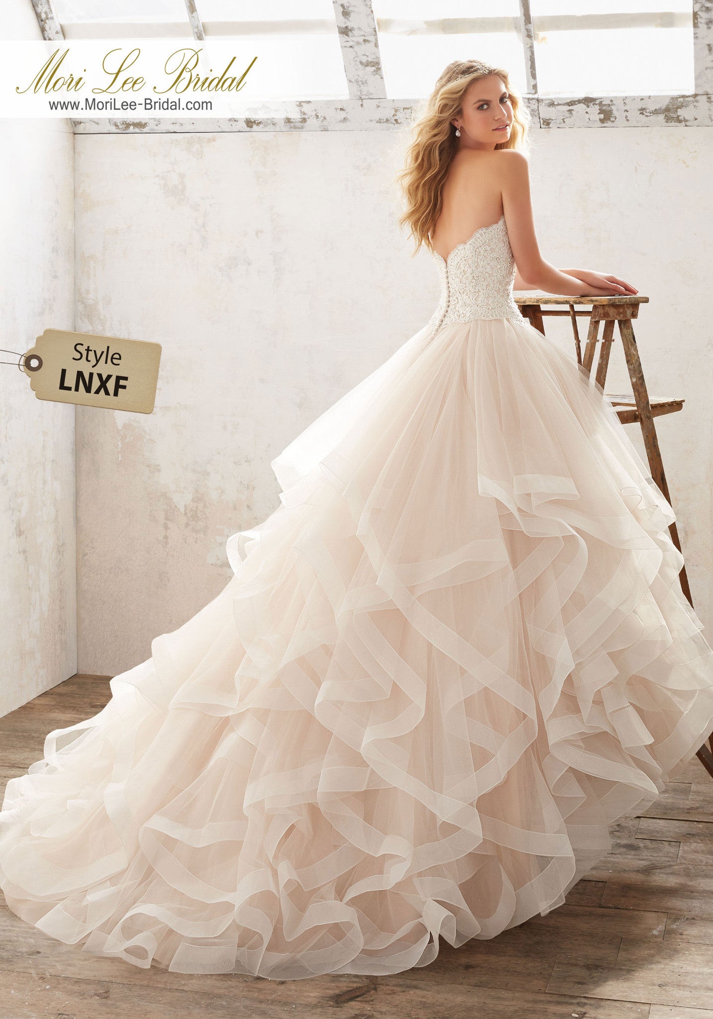Suave y etéreo, este vestido de novia con volados tiene un corpiño de encaje Alençon con cuentas de cristal y una falda de tul con volantes y ribete. LNXF*
